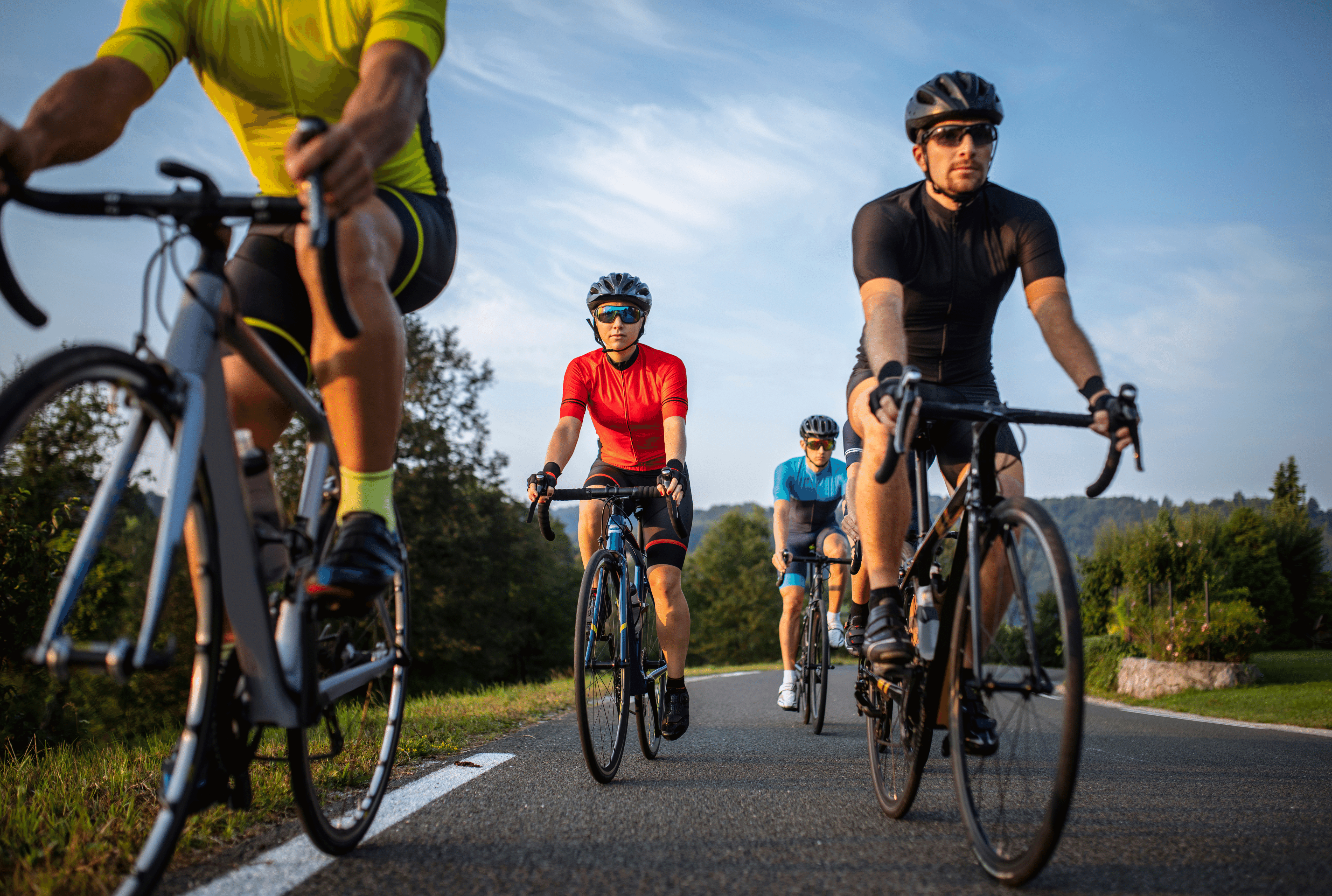 a group of cyclists riding behind each other on a flat road