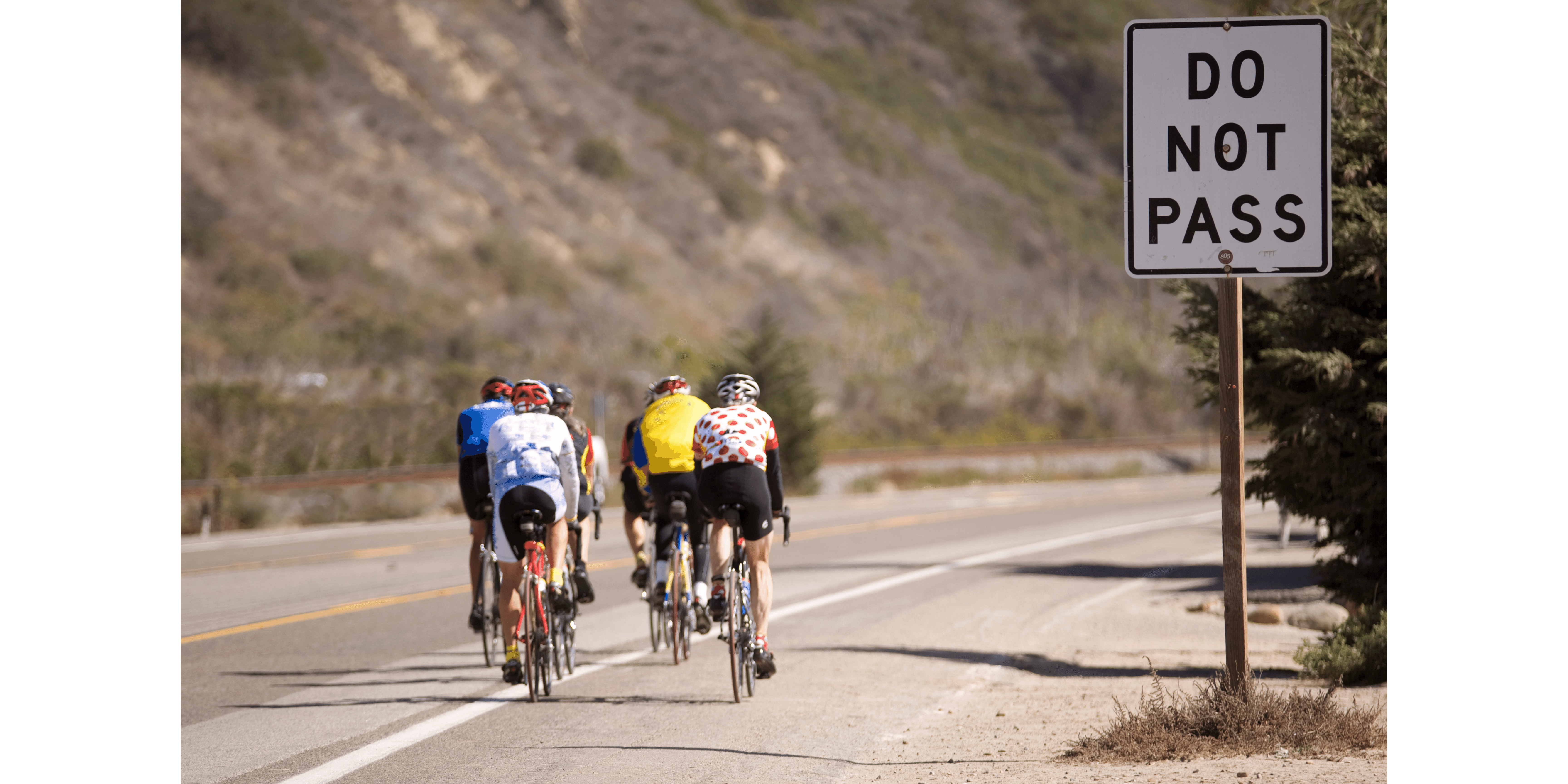 a group of cyclist going past a do not pass sign