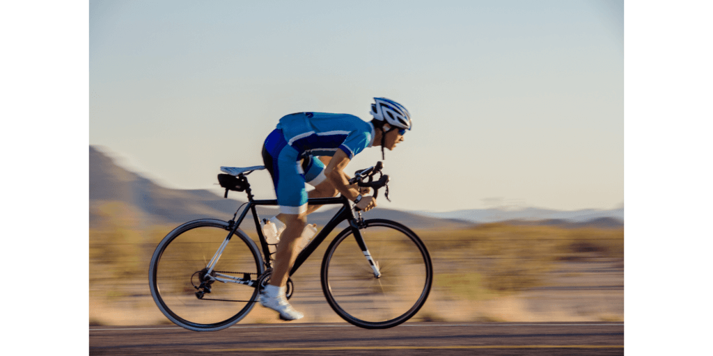 a man cycling fast on a road bike