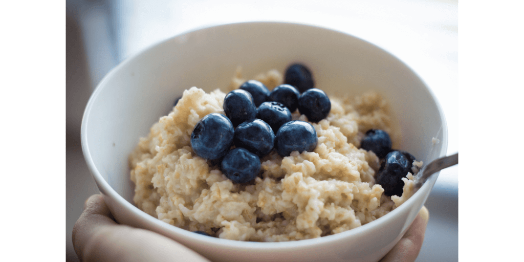 a bowl of oat porridge topped with blueberries
