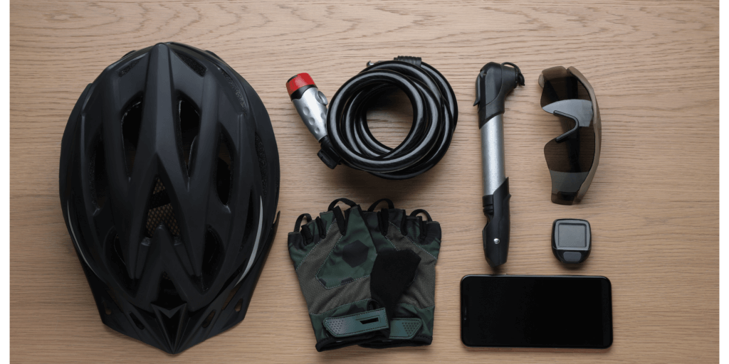 a cycling helmet, hand pump, lock, gloves and glasses on a table