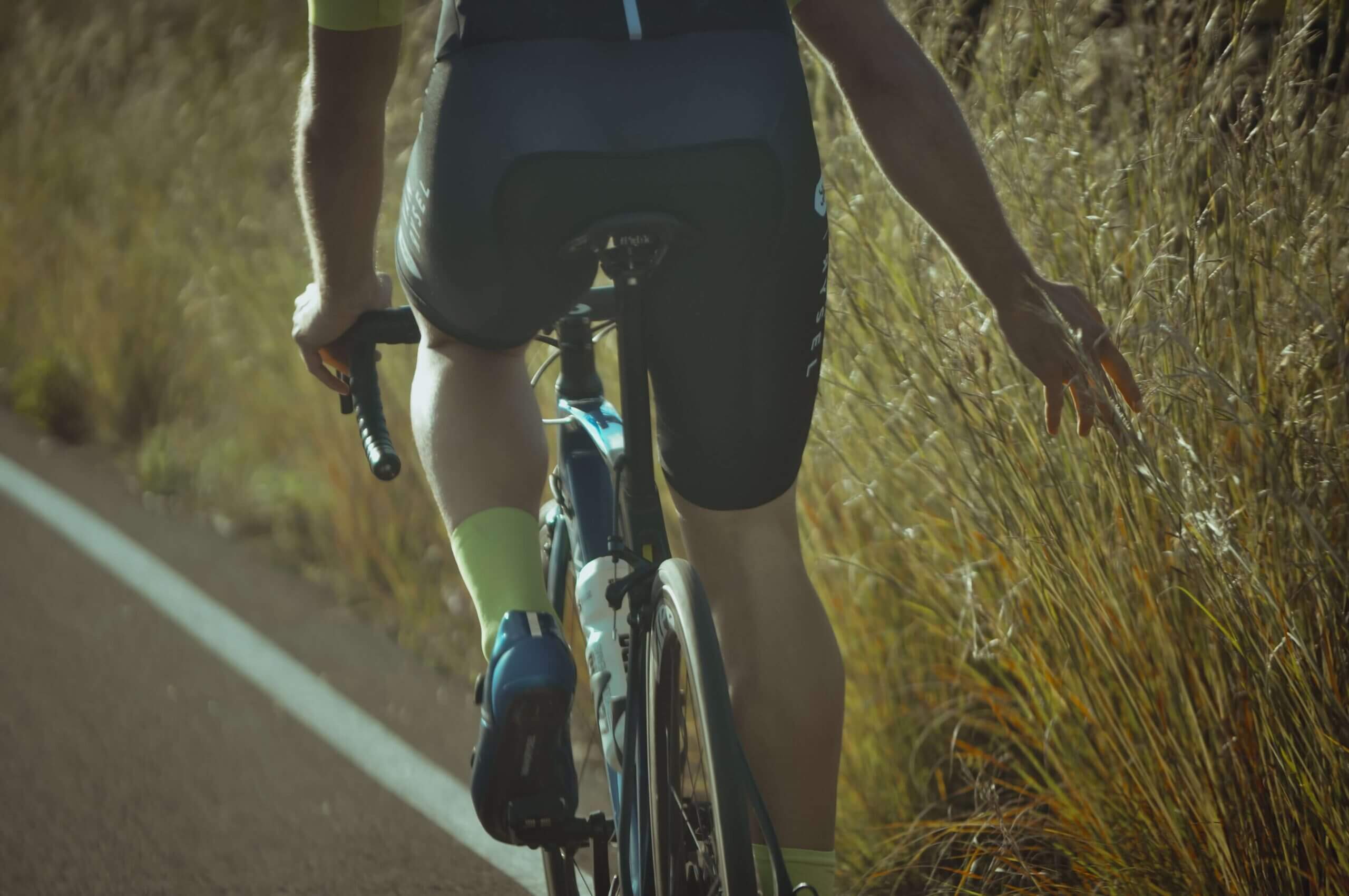 the lower half of a male cyclist wearing cycling shorts