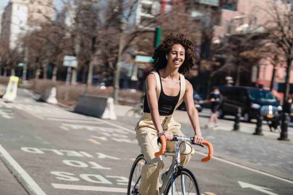 a young woman casually cycling and smiling in an urban area