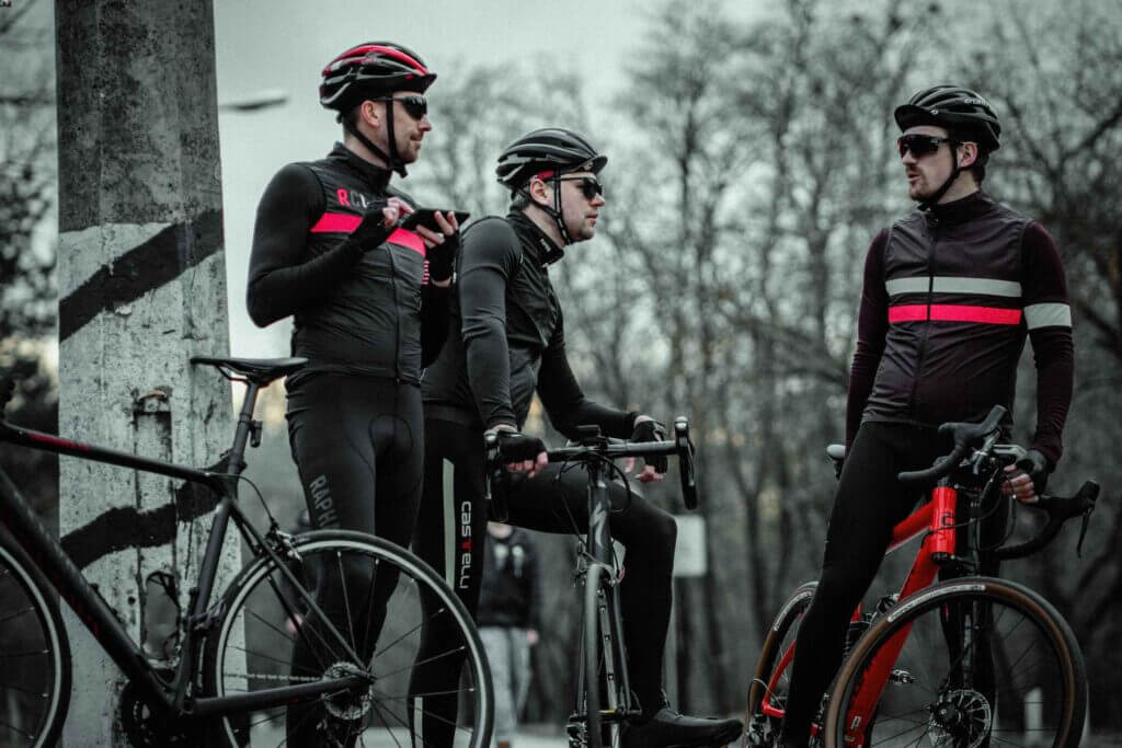3 male cyclists standing beside each other with their bikes, dressed in winter cycling clothes
