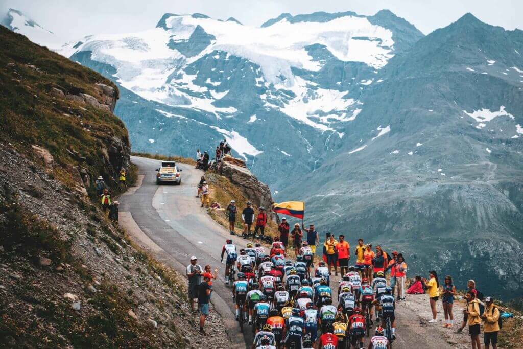 a group of cyclists in the tour de france cycling up a mountain