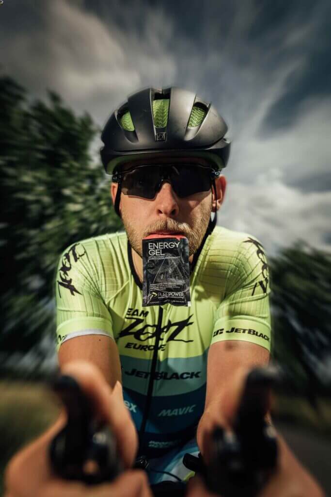 a tour de france cyclist with an energy gel in his mouth