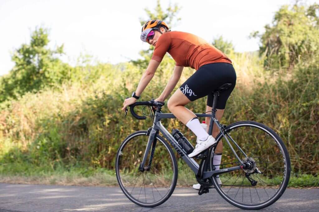 a woman cyclist on a road bike in the countryside