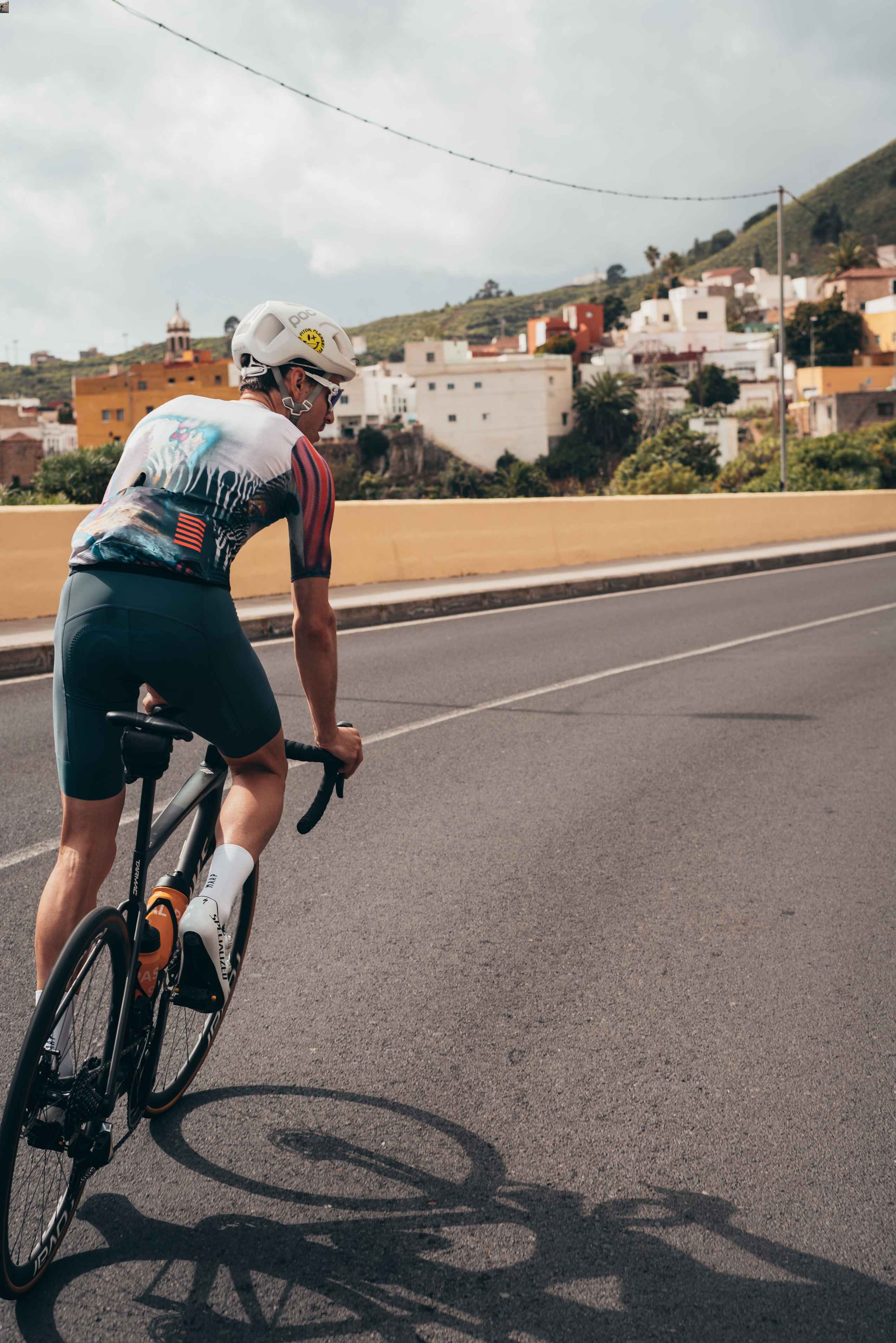 a male cyclist cycling uphill, out of the saddle