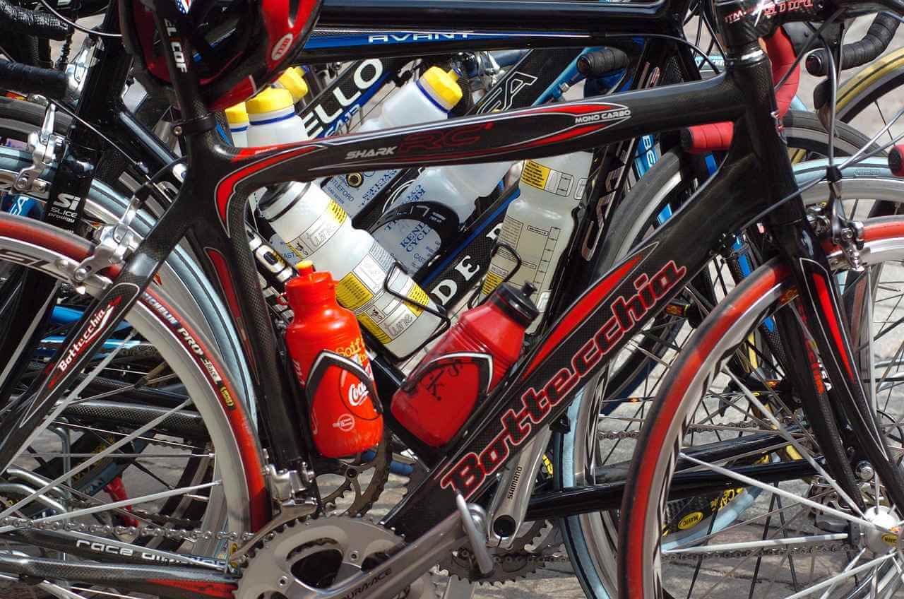 a close up of a tour de france cyclists bike with two water bottles