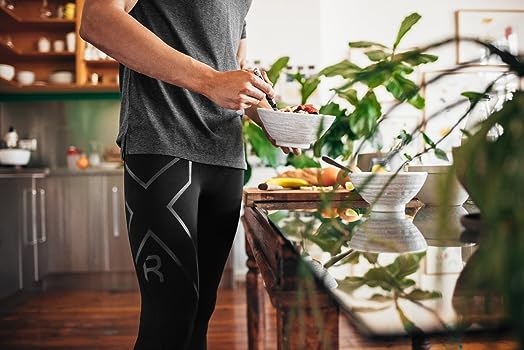 a man wearing compression leggings for recovery as he makes food