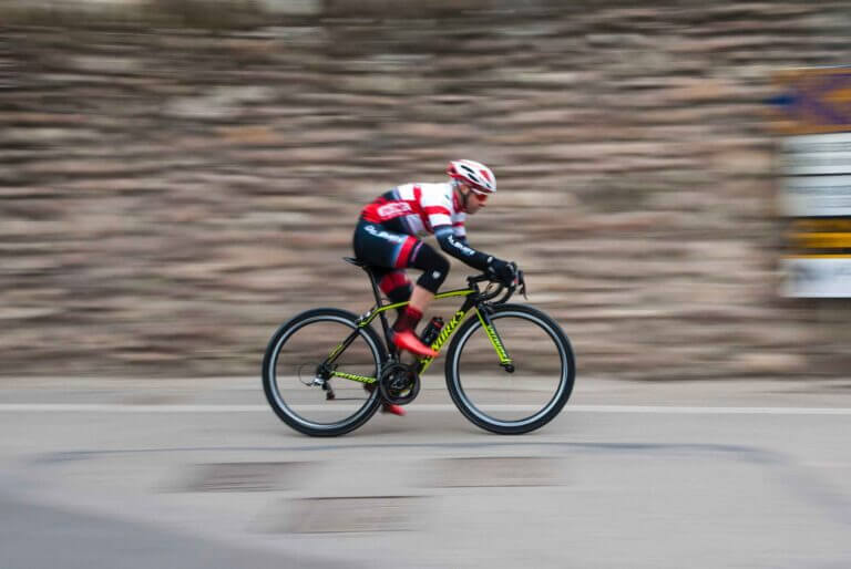 a road cyclist cycling fast with a blurry background