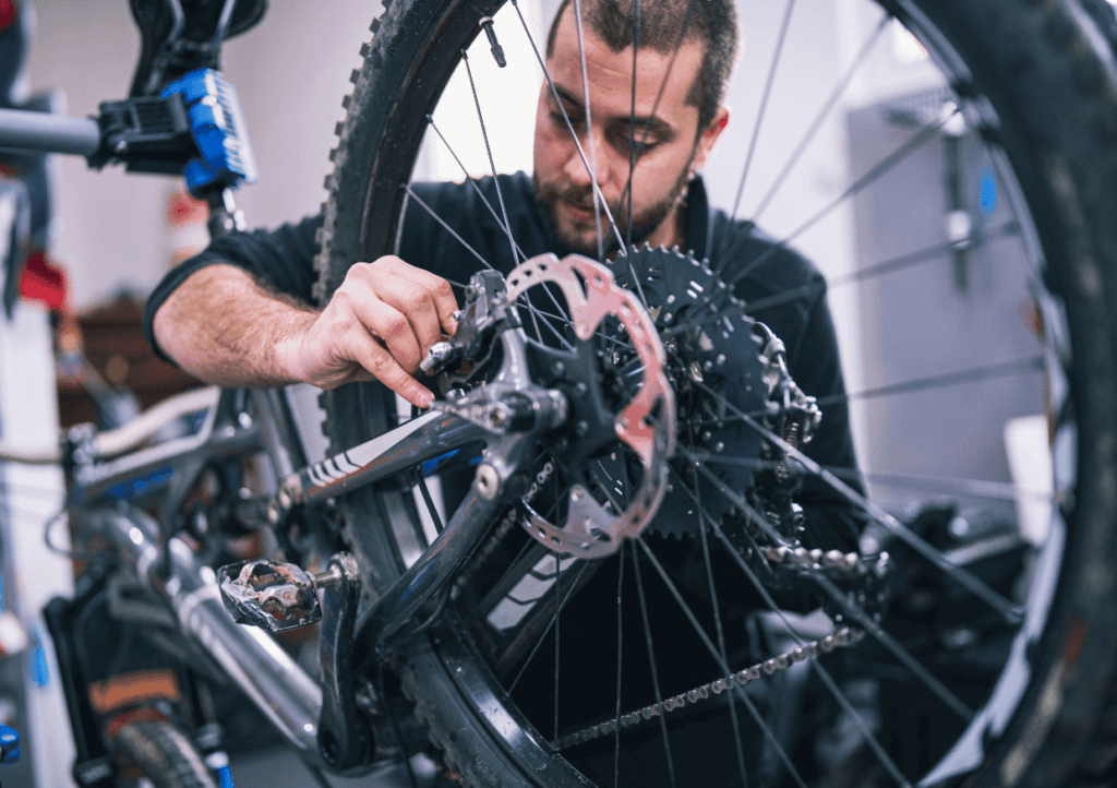 a bicycle mechanic working on the disc brakes