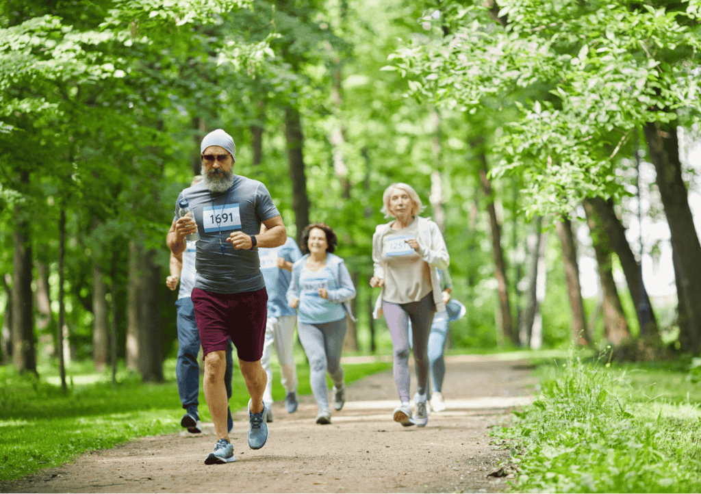 a group of people running on a path in a park, part of a fun run