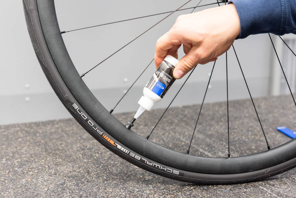 someone filling the tubeless tyre with sealant