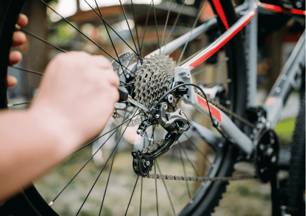 someone adjusting the gears of a road bike with a screwdriver