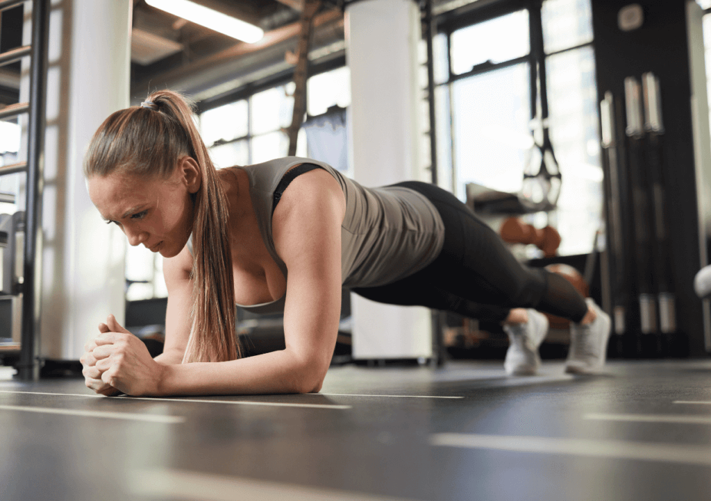 a woman doing the plank exercise in a gym
