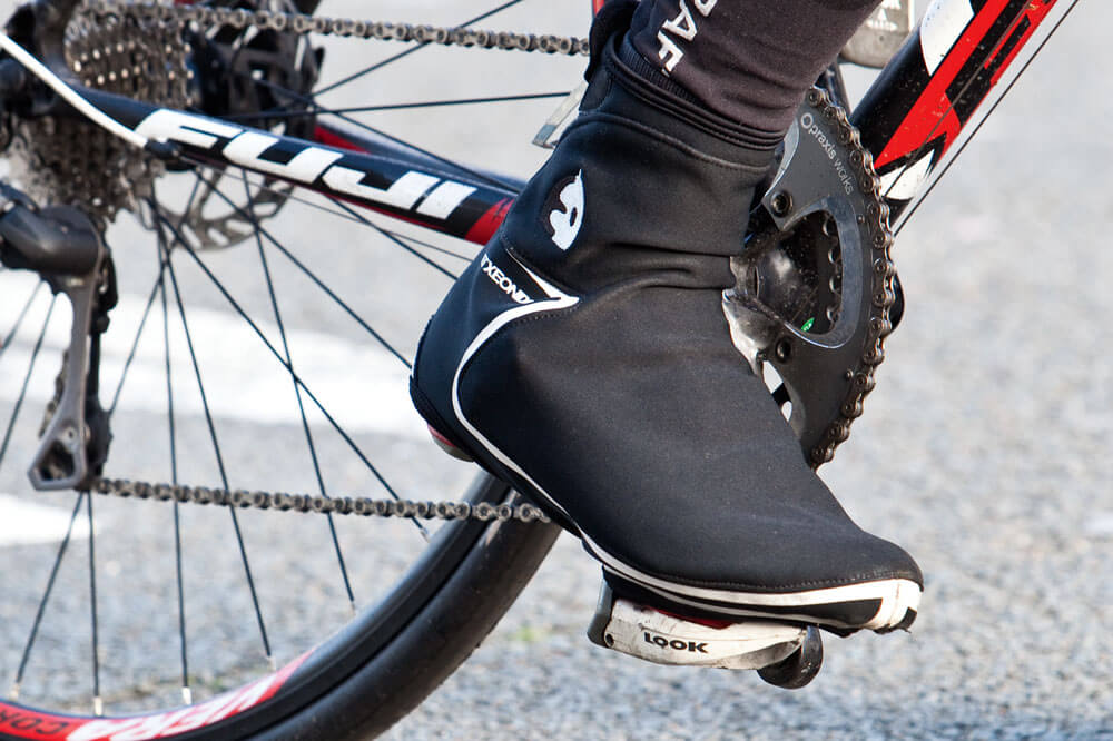a cyclist wearing overshoes to protect their feet 