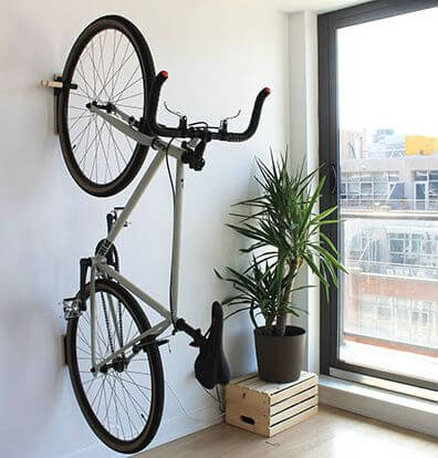 a bike hanging from a hook on a wall in an apartment