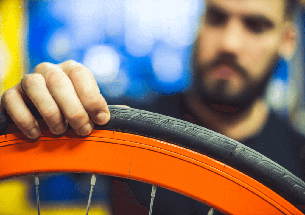 A man inspecting the wear of a bike tire